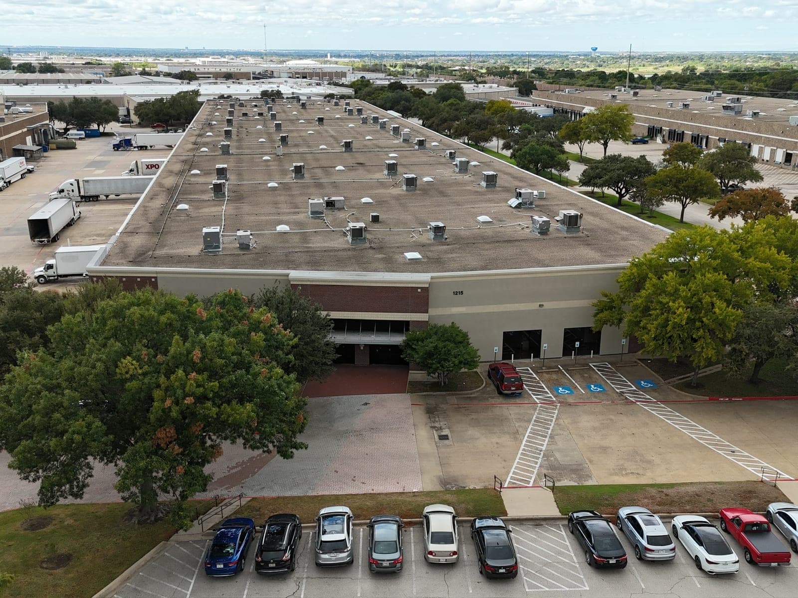 Aerial view of the ACS facility in its industrial park, with the Dallas–Fort Worth skyline behind it