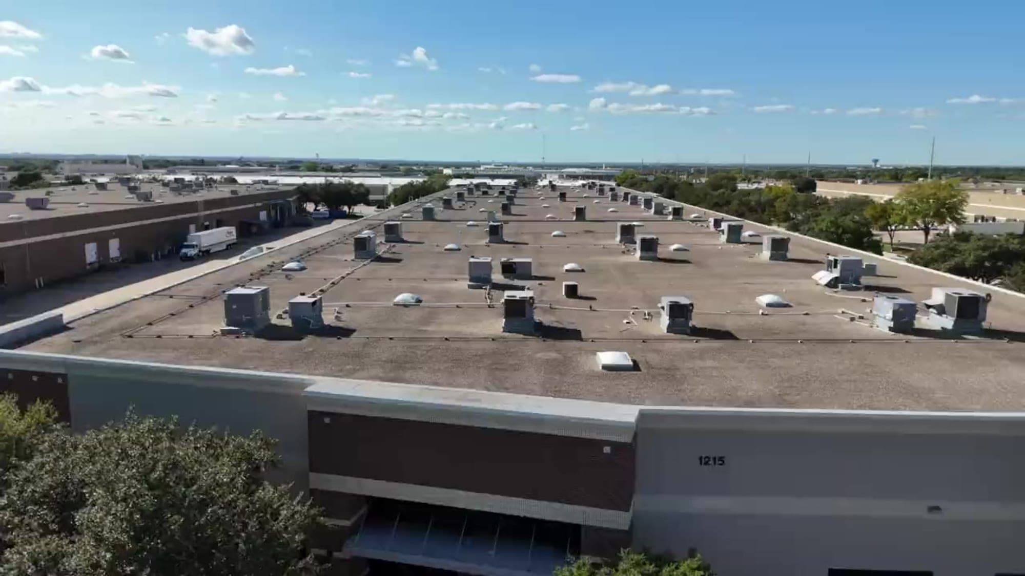 Aerial view of the ACS facility in Carrollton, Texas, with trailers at its dock doors